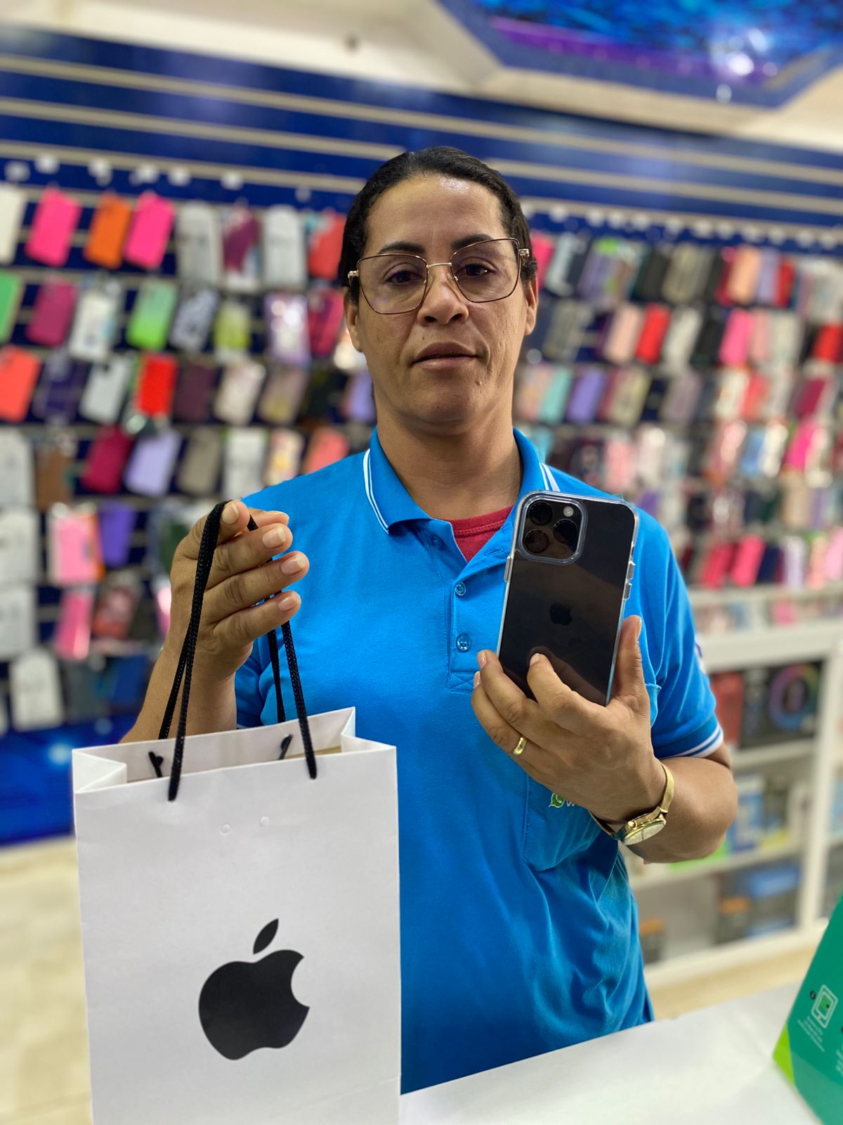 Cliente da capas.com mostrando seu novo iPhone na loja